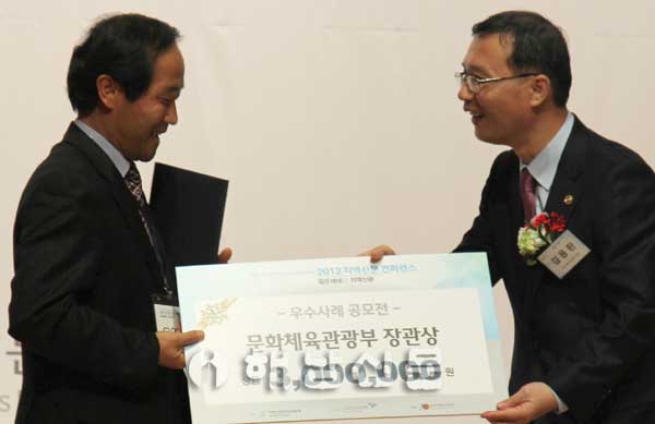 본사 오영상 편집국장이 김용환 문광부 제2차관으로부터 상장과 상금을 받고 있다.