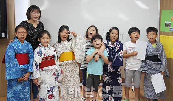 ▲ 공공도서관 프로그램에 참여한 학생들이 기모노 입기 체험을 하며 일본말로 인사를 하고 있다.
