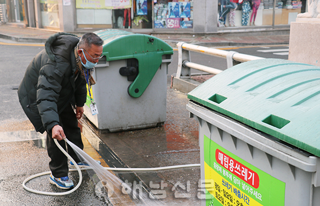 ▲ 쓰레기 수거차량이 쓰레기를 수거한 이후 김춘영 씨가 물청소에 나서고 있다.