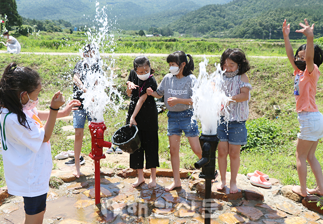 ▲ 생태연못에서 여학생들이 펌프질 놀이를 하고 있다.