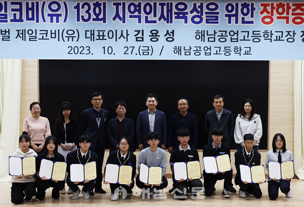 ▲제일코비 김용성 대표(뒷줄 오른쪽에서 네번째)가 장학금을 수여한 뒤 학교 관계자, 학생들과 함께 기념사진을 찍고 있다.