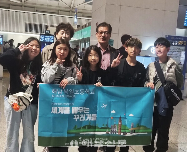 ▲김재국 씨(뒷줄 오른쪽)가 해외탐방에 나선 학생들과 공항에서 기념사진을 찍고 있다.