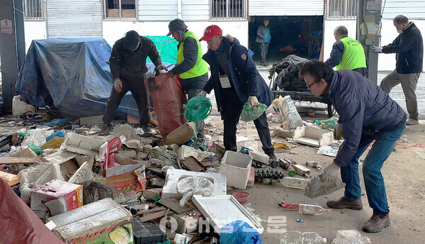▲상인회장과 시장관리사, 공공근로자들이 5일시장 야채동에 방치된 쓰레기를 치우고 있다.