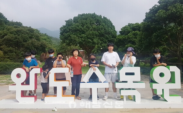▲등대원 생활지도원(왼쪽 여섯번째)과 김구성 씨(왼쪽 여덟 번째)가 등대원에서 생활하는 아동들과 함께 완도수목원 나들이에 나섰다. 