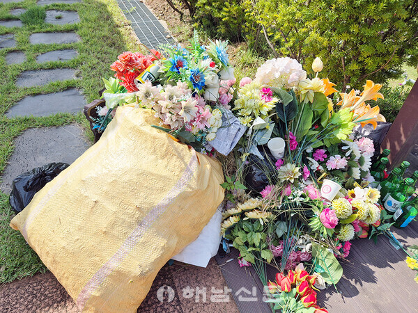 ▲남도광역추모공원 자연장지 앞에 폐기를 앞둔 플라스틱 조화들이 마대자루에 담겨있다.