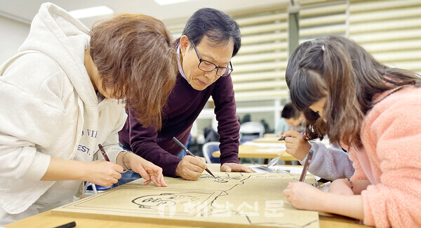 ▲전정호(가운데) 소장이 판화교실에서 판화 작업을 지도하고 있다.