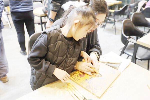 ▲박은경 씨가 8살 딸인 정라원 양과 고 공정엽 할머니를 기리는 판화를 만들고 있다.