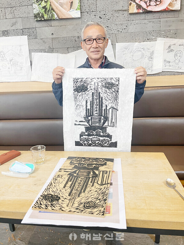 ▲박철희 유족회장이 옥매광산 희생자 추모비를 옮겨놓은 판화를 보여주고 있다.