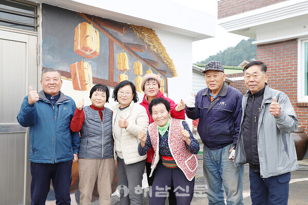 ▲지난 12일 온인마을 주민들이 메주가 그려진 벽화 앞에서 기념사진을 촬영했다.